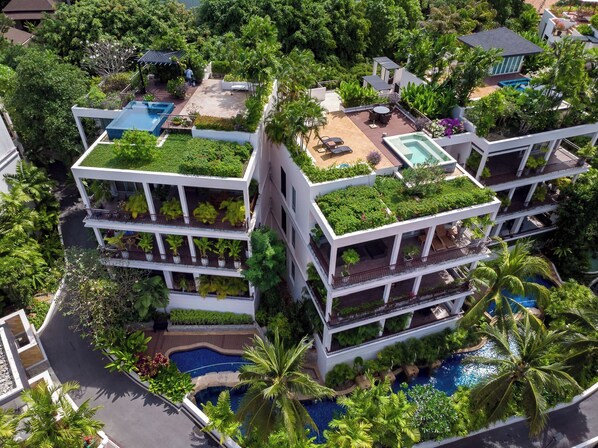 A multi-story hotel with rooftop gardens, balconies, and a swimming pool. - Kata gardens 2 bedroom near Kata beach 3B (Karon)