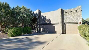 Un bâtiment moderne avec une façade en pierre, un garage et une allée pavée.