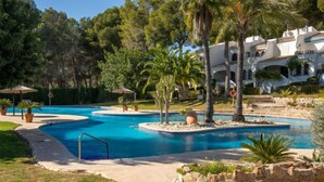 A resort with a large, winding pool surrounded by palm trees and a stone wall. - Los Lagos by Interhome (Dénia)