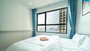 Une chambre d’hôtel avec une grande fenêtre, un lit et une vue sur le paysage urbain.