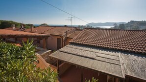 A residential area with terracotta-tiled roofs, a clear sky, and a distant view of the sea. - APP.TI NORSI - NORSI - MONO (Capoliveri)