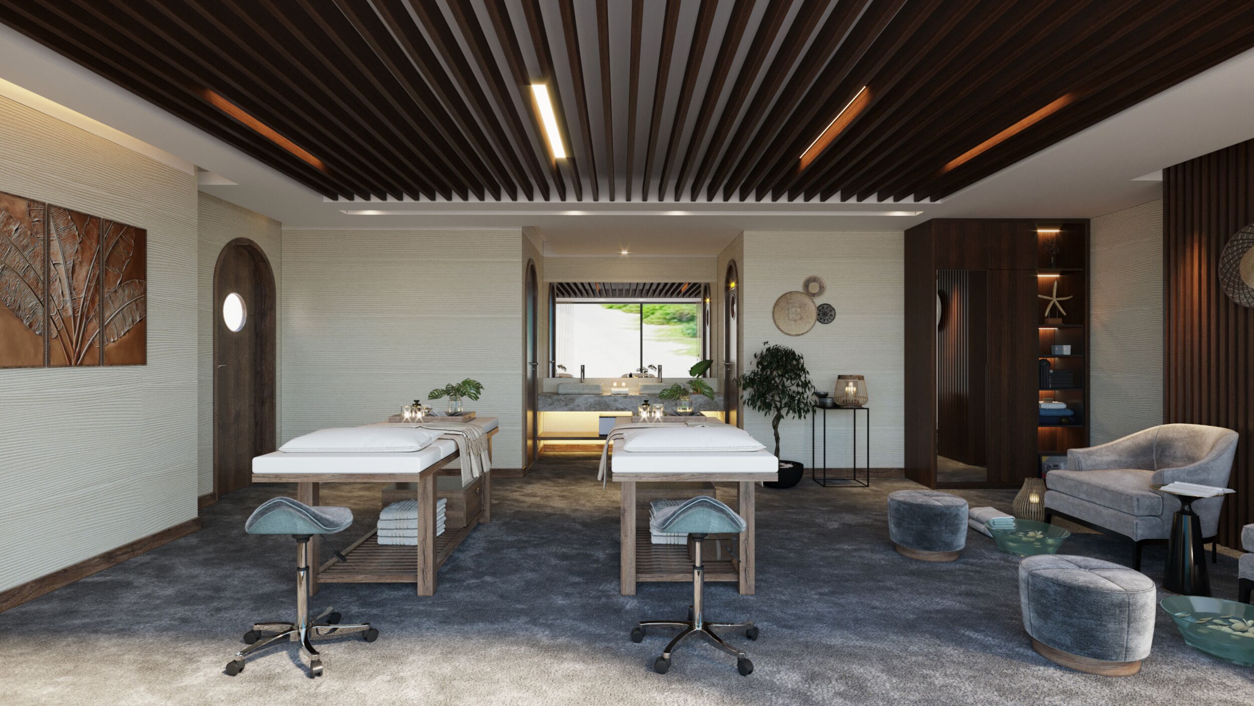 A modern spa room with two massage tables, a reception desk, and a seating area with a chair and ottoman.