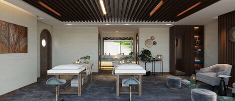 A modern spa room with two massage tables, a reception desk, and a seating area with a chair and ottoman.