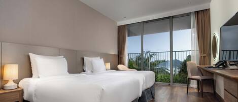 Une chambre d’hôtel avec deux lits, un bureau, une chaise et une grande fenêtre donnant sur un beau paysage.