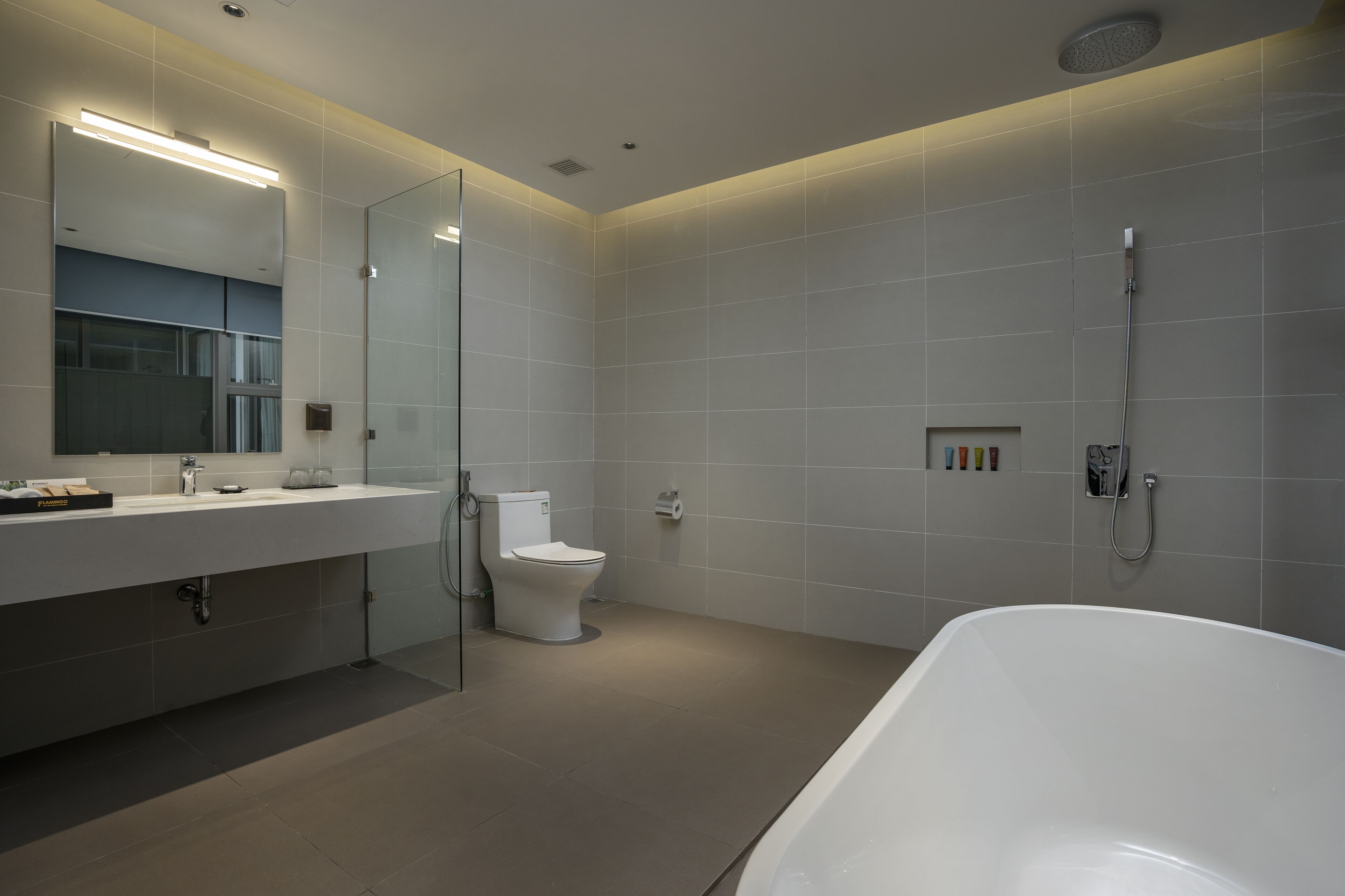 Un baño moderno con una bañera grande, un inodoro y un lavabo con espejo.