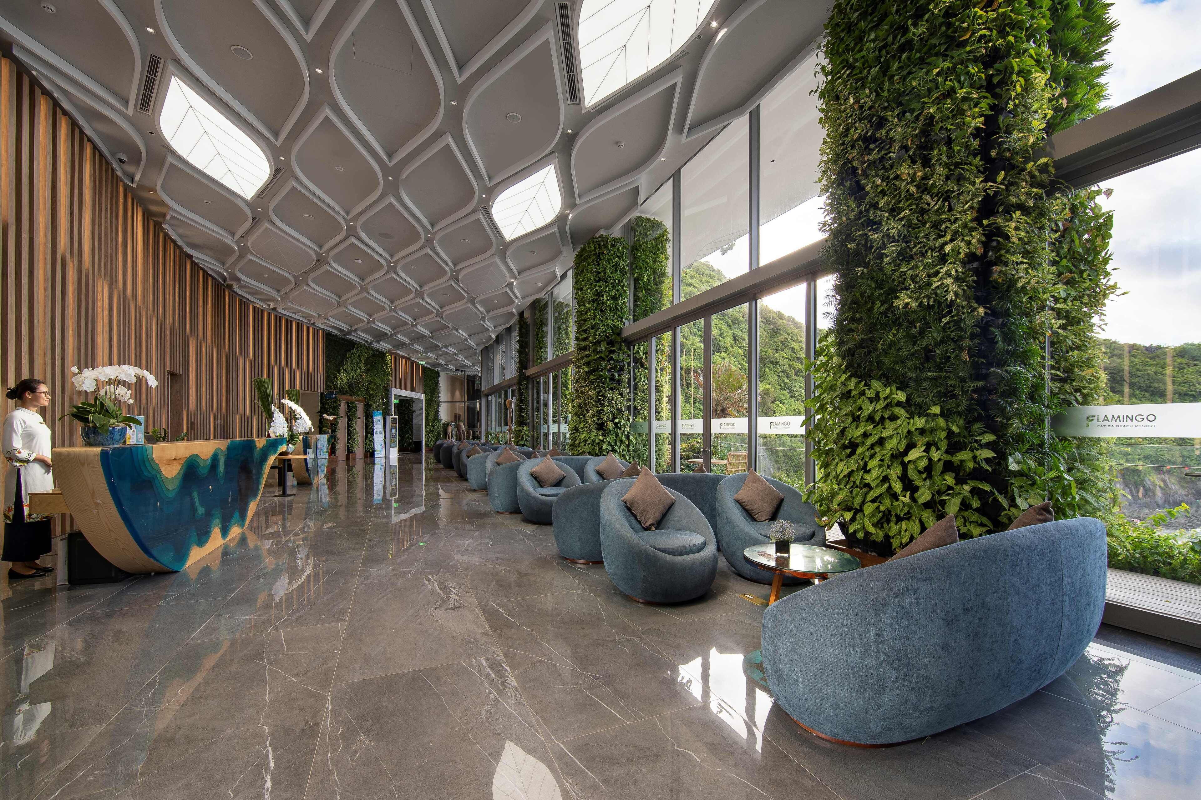 A spacious lobby with a reception desk, seating area, and large windows offering views of the outdoors.