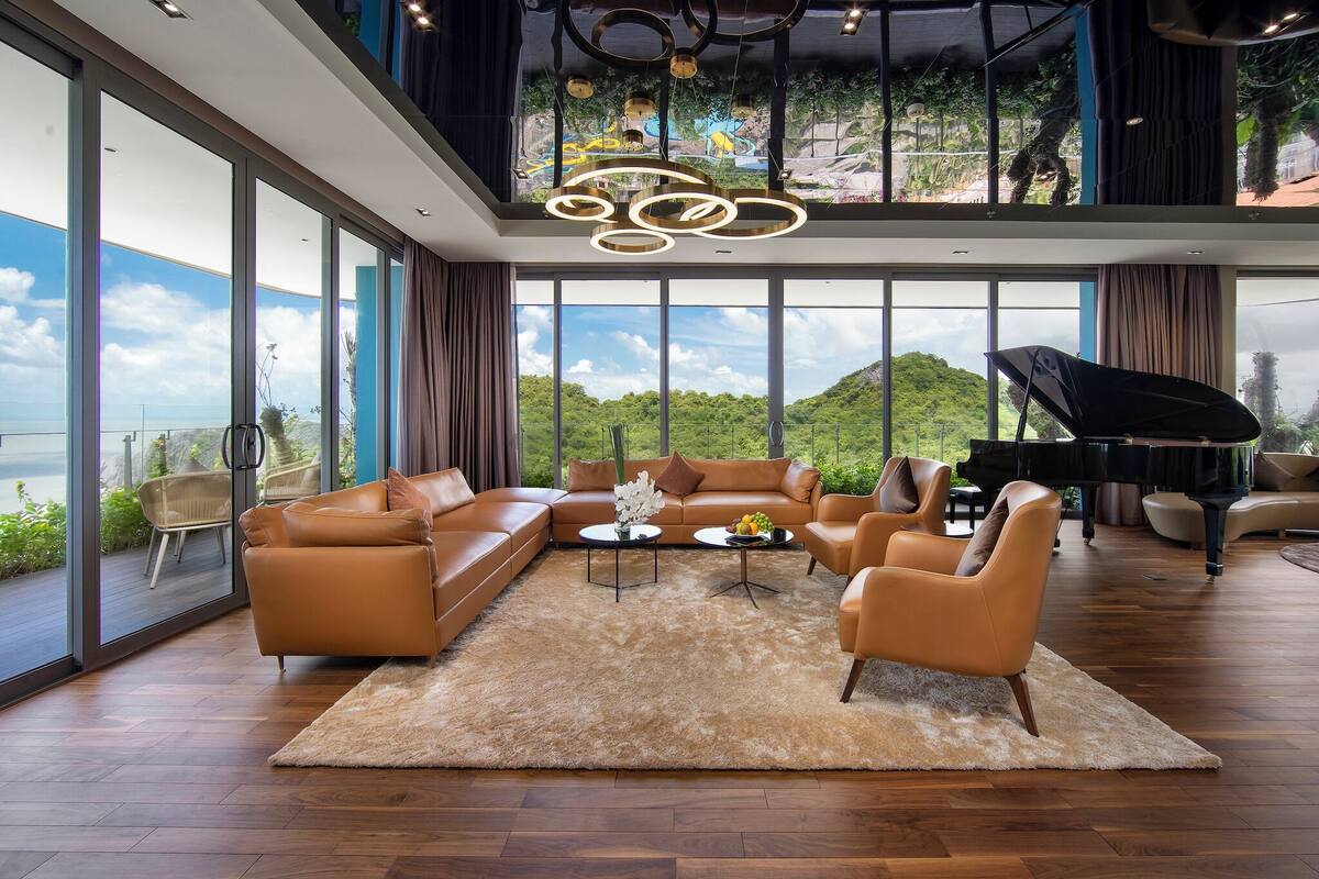 Un salon spacieux, doté d’un grand canapé, d’une table basse et d’un magnifique piano à queue.