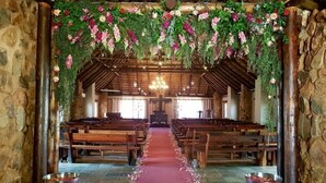 Interior de una iglesia con bancas de madera, un pasillo central y una alfombra roja.