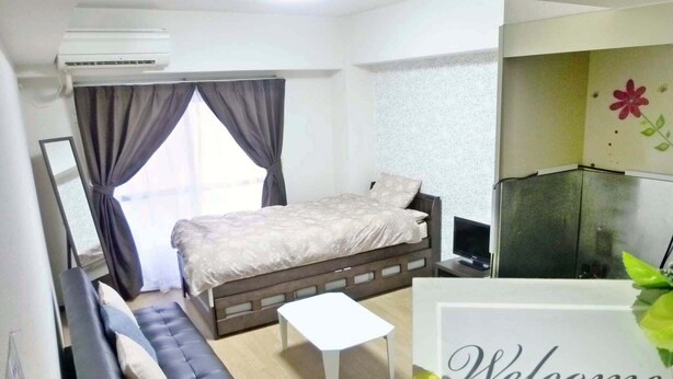 A bedroom with a bed, a sofa, a TV, and a 'Welcome' sign. - Free bike and free WIFI 204 Take it easy (Kyoto)