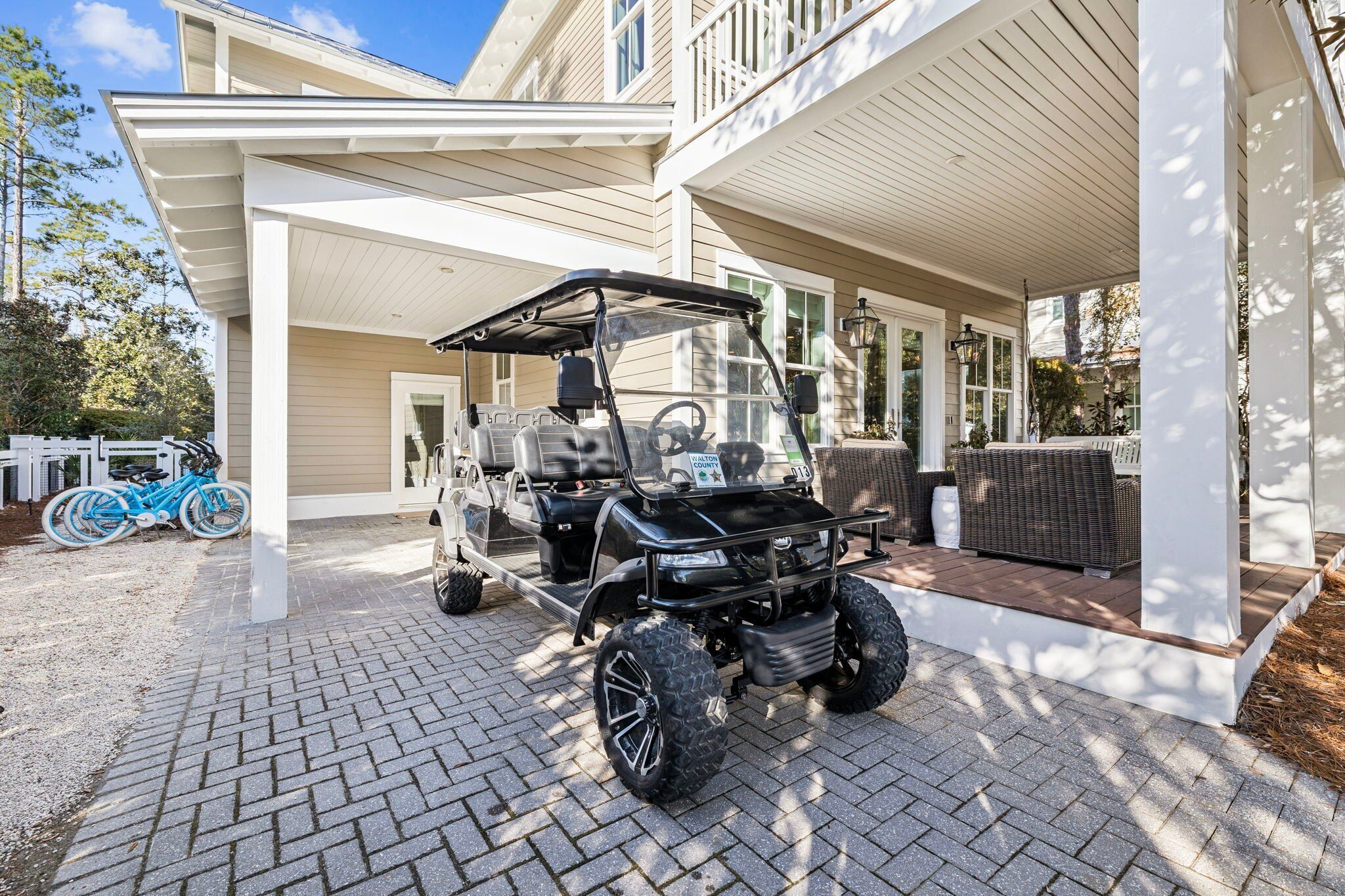 A covered patio area with a golf cart parked in front.
