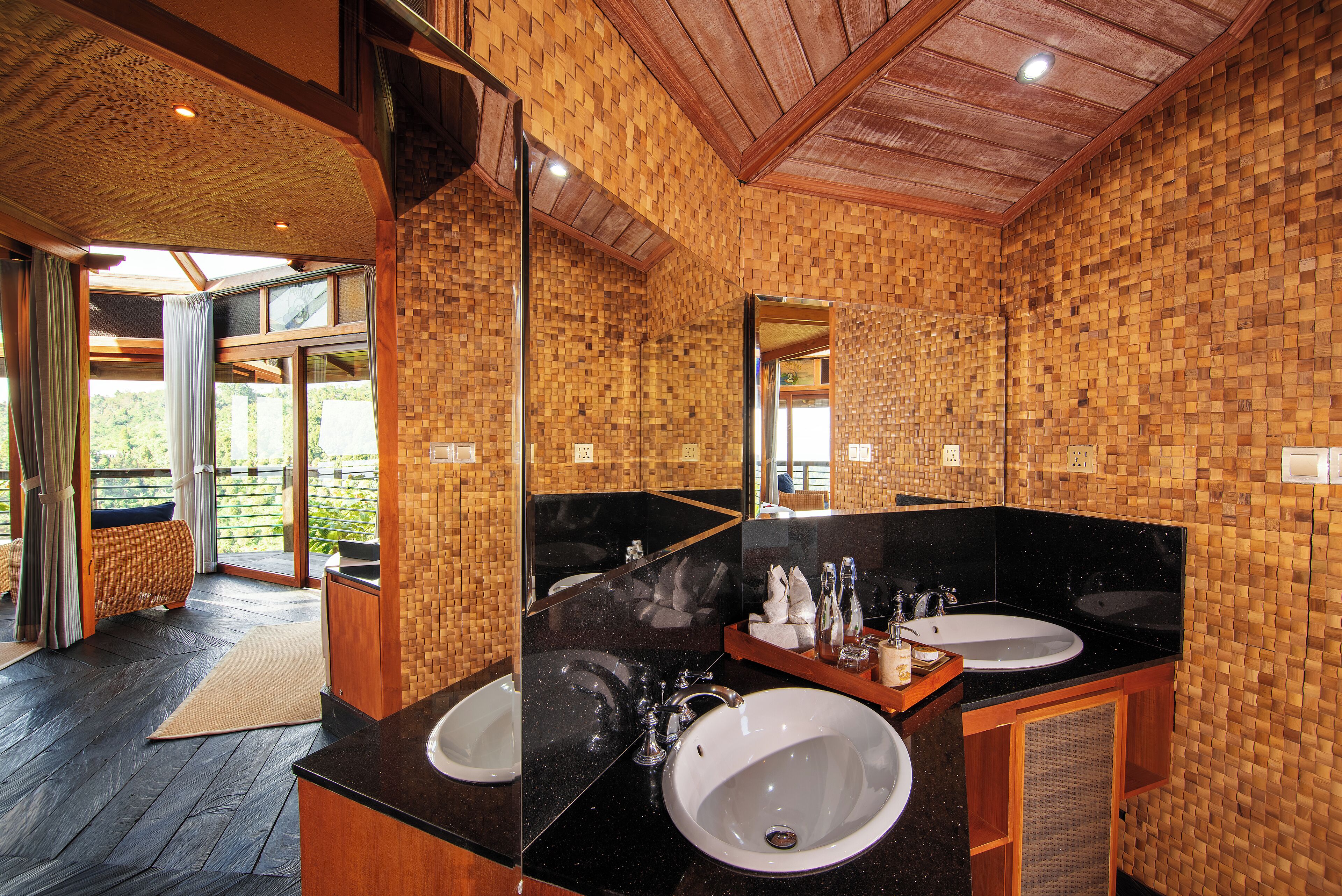 A bathroom with two sinks, a large mirror, and wooden walls.