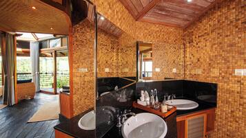 A bathroom with two sinks, a large mirror, and wooden walls.