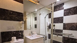 A modern bathroom with a toilet, sink, and glass-enclosed shower area. - Dreamer Hotel (Budai)