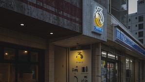 Un edificio con un cartel que indica '3 PLACE' y un logotipo con un '3' estilizado y una luna creciente.