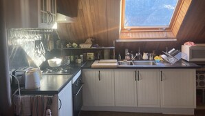 A kitchen with wooden cabinets, a window, and a skylight. - BRIGHT, SPACIOUS, COSY BARN AT THE FOOT OF THE CHEMIN DE SAINT-JACQUES (GAVARNIE GEDRE)