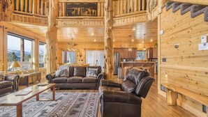 Ein geräumiges Blockhaus-Interieur mit Wohnbereich, Essbereich und Küche.