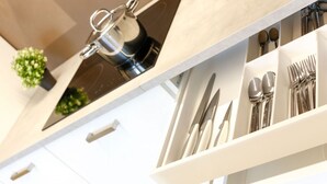 Una cocina moderna con cafetera integrada y cajón para utensilios.