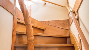 A wooden staircase with a handrail and a window at the top. - Ryokan Fuji Heights (Fujikawaguchiko)