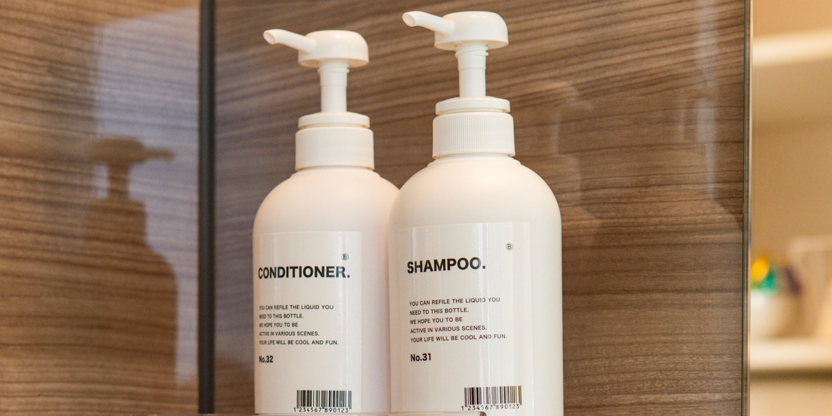 Two bottles of conditioner and shampoo with pumps, labeled No. 32 and No. 31, on a shelf.