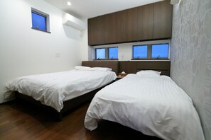 Una camera da letto con due letti, una finestra e un'armadio in legno.