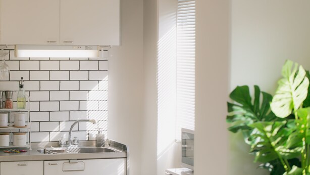 A kitchen with white cabinets, a stainless steel sink, and a window with blinds. - Akebono 5-D (Naha)