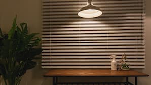 A table with a bottle and a spray bottle, a hanging light fixture, and a plant. - Akebono 5-D (Naha)