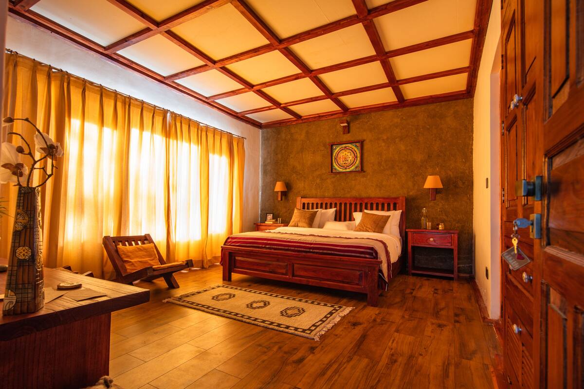 A traditional room with a wooden bed, a desk, and a chair.