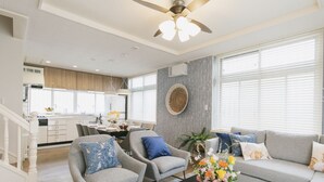 A modern living room with a sofa, armchairs, and a dining area. - Sunset Breeze Chatan  (Chatan)