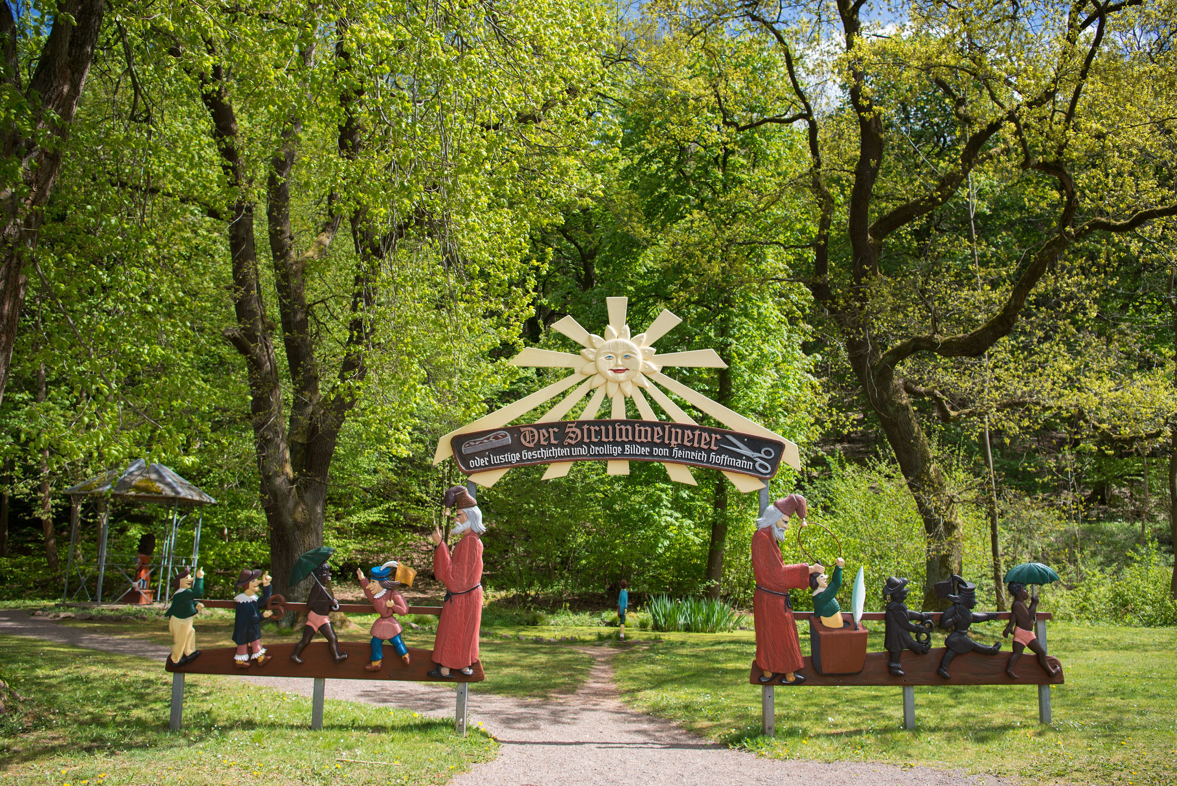 Entrada de parque con un letrero y bancos.