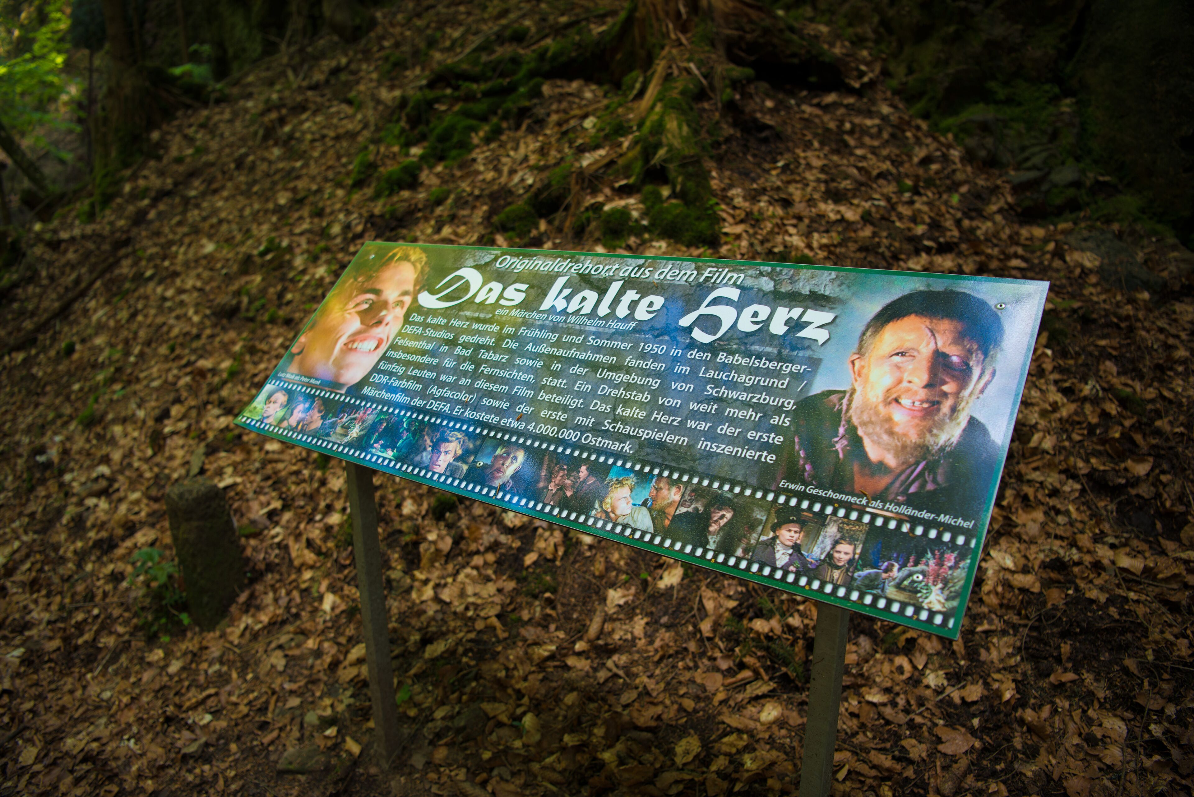 A sign with text and images, likely informational, placed outdoors with natural background.