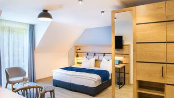 Un dormitorio moderno con cama, mesita de noche y televisor.