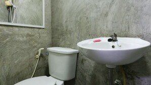 Un baño con inodoro, lavamanos y espejo.