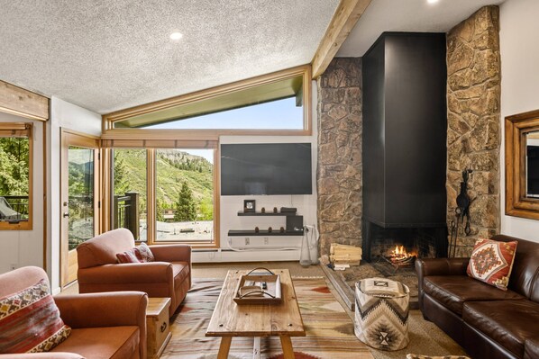 TV, fireplace, books - Ski-In/Ski-Out Escape with Private Balcony, Cozy Fireplace, Hot Tubs, Parking & Easy Elevator Access (Snowmass Village)