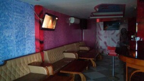 A restaurant with booths and a bar area. - Checkpoint Inn (Mombasa)