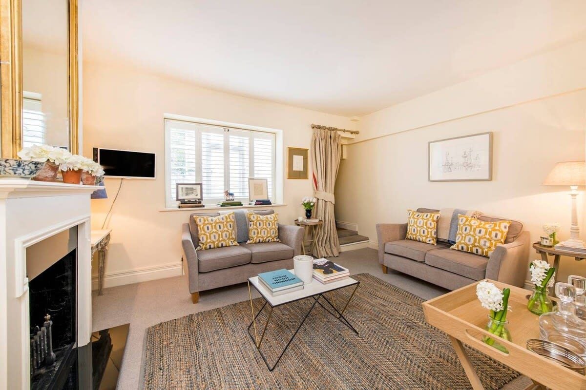 A living room with two sofas, a coffee table, a fireplace, and a television.