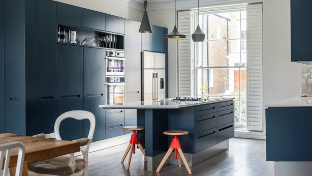 A modern kitchen with dark cabinetry, a central island, and pendant lighting. - Fantastic 4 Bed House in Iconic Camden (London)
