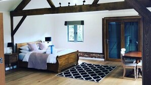 Een slaapkamer met een houten plafond, een bed, een raam en een deur.