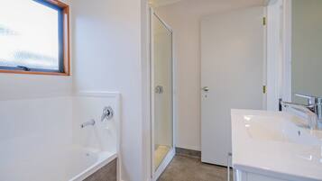 A bathroom with a bathtub, a shower, and a sink.