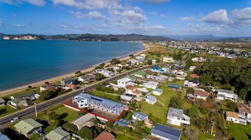 Vista aérea de un pueblo costero con casas, caminos y una playa.