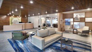 A modern hotel lobby with a wooden ceiling, a reception desk, a sofa, armchairs, and a patterned carpet.