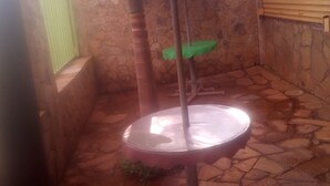 Una habitación con paredes de piedra, una mesa redonda y una silla verde.