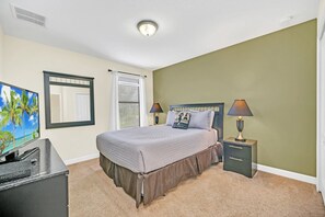 A bedroom with a bed, bedside tables, a TV, and a window with blinds. - Family Fun & Secluded Pool! Gated Resort Near Disney (Davenport)