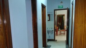 A hallway with tiled flooring, wooden doors, and a visible sink area. - EL Paso Gardens Kisumu (Kisumu)