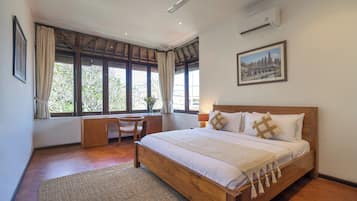Un dormitorio con cama de madera, un escritorio, una silla y una ventana con cortinas.