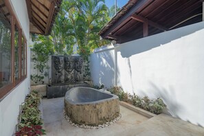 A courtyard with a stone sculpture, a concrete basin, and potted plants. - 7-bedroom private estate in Seminyak, perfect for large groups and families. Accomodate up to 18 guests. Jasmina Estate includes daily breakfast, a private chef, airport transfers, complimentary massages, housekeeping, and a dedicated driver. (Seminyak)