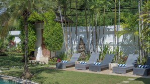 A poolside area with lounge chairs and a statue. - 7-bedroom private estate in Seminyak, perfect for large groups and families. Accomodate up to 18 guests. Jasmina Estate includes daily breakfast, a private chef, airport transfers, complimentary massages, housekeeping, and a dedicated driver. (Seminyak)