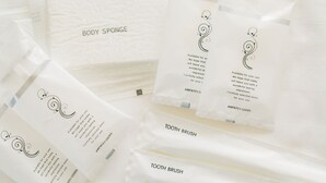 Several white packages labeled with different items such as body sponge, tooth brush, and Amenity Goods. - Akebono 5-A (Naha)