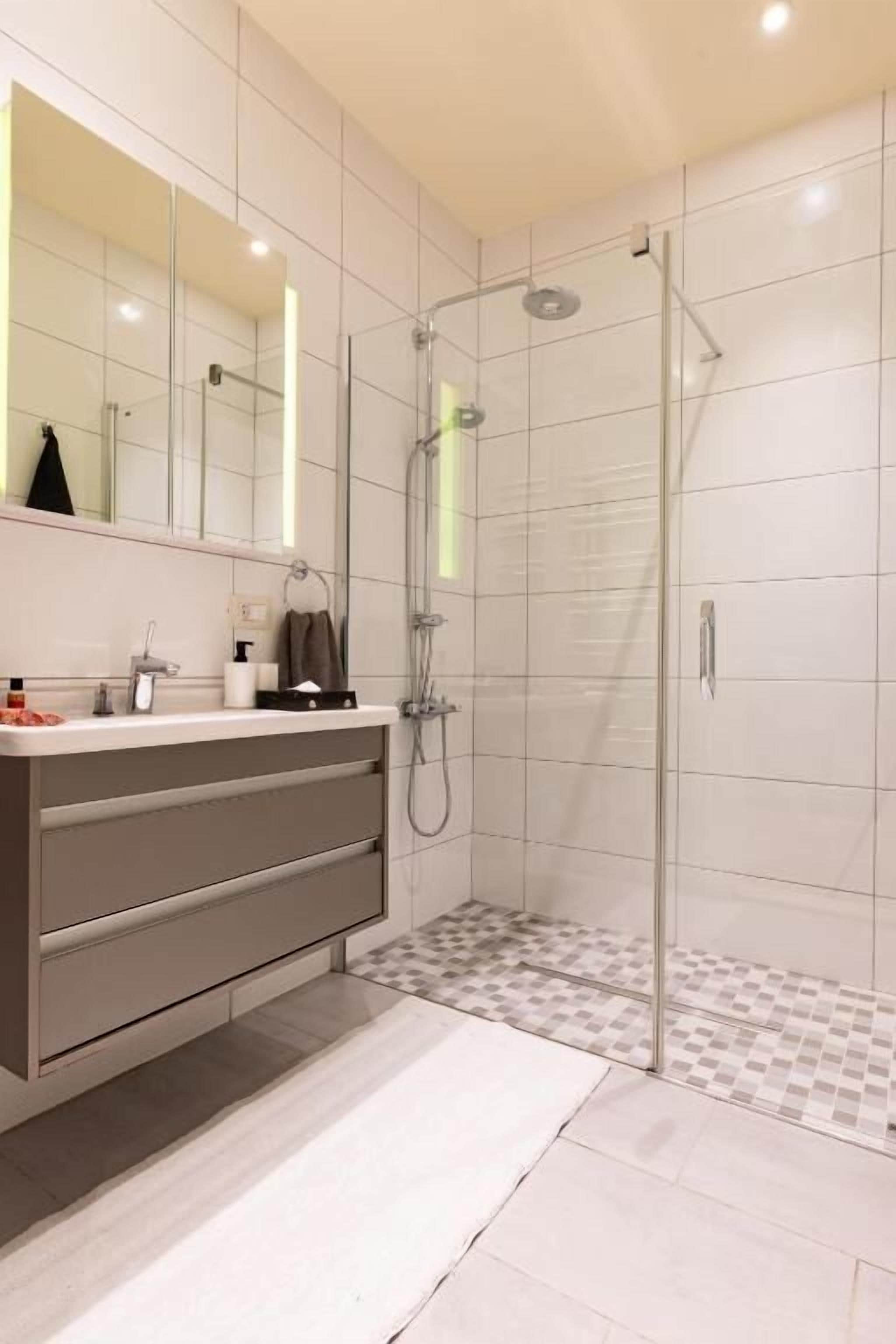 Deluxe appartement | Badkamer | Een regendouche, designer toiletartikelen, een haardroger, badjassen