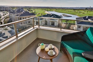 Enjoy a serene view of the golf course and surrounding landscape from this balcony.