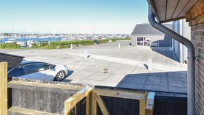 Un port de plaisance avec des bateaux, un parking couvert et un bâtiment portant une enseigne.